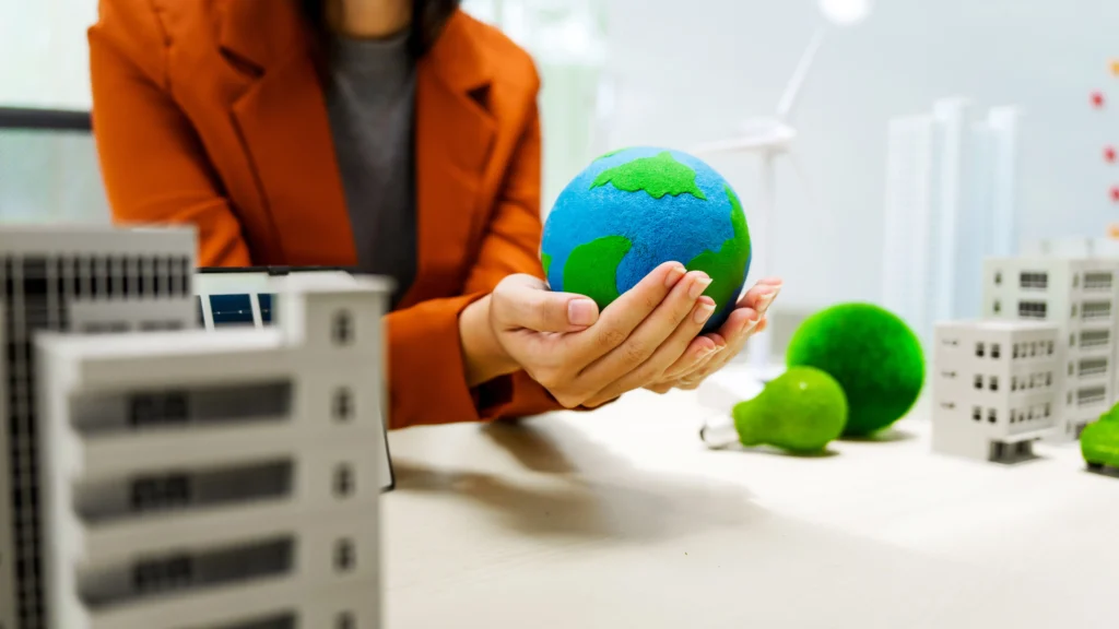 Una persona sostiene un globo terráqueo en sus manos, transmitiendo el compromiso ambiental que se vuelve esencial al comprender las medallas y distintivos de EcoVadis.