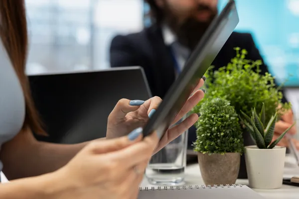 Una persona revisa estrategias de sostenibilidad empresarial en una tableta, analizando cómo mejorar mi calificación en Ecovadis mediante prácticas más responsables.